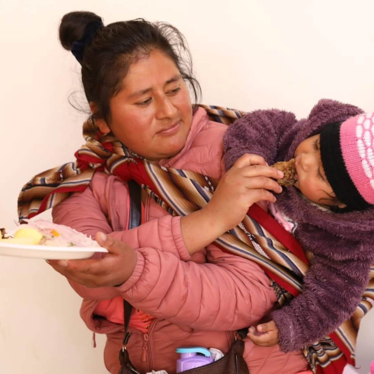 madre de familia dándole de comer a su hijo seguridad alimentaria Perú